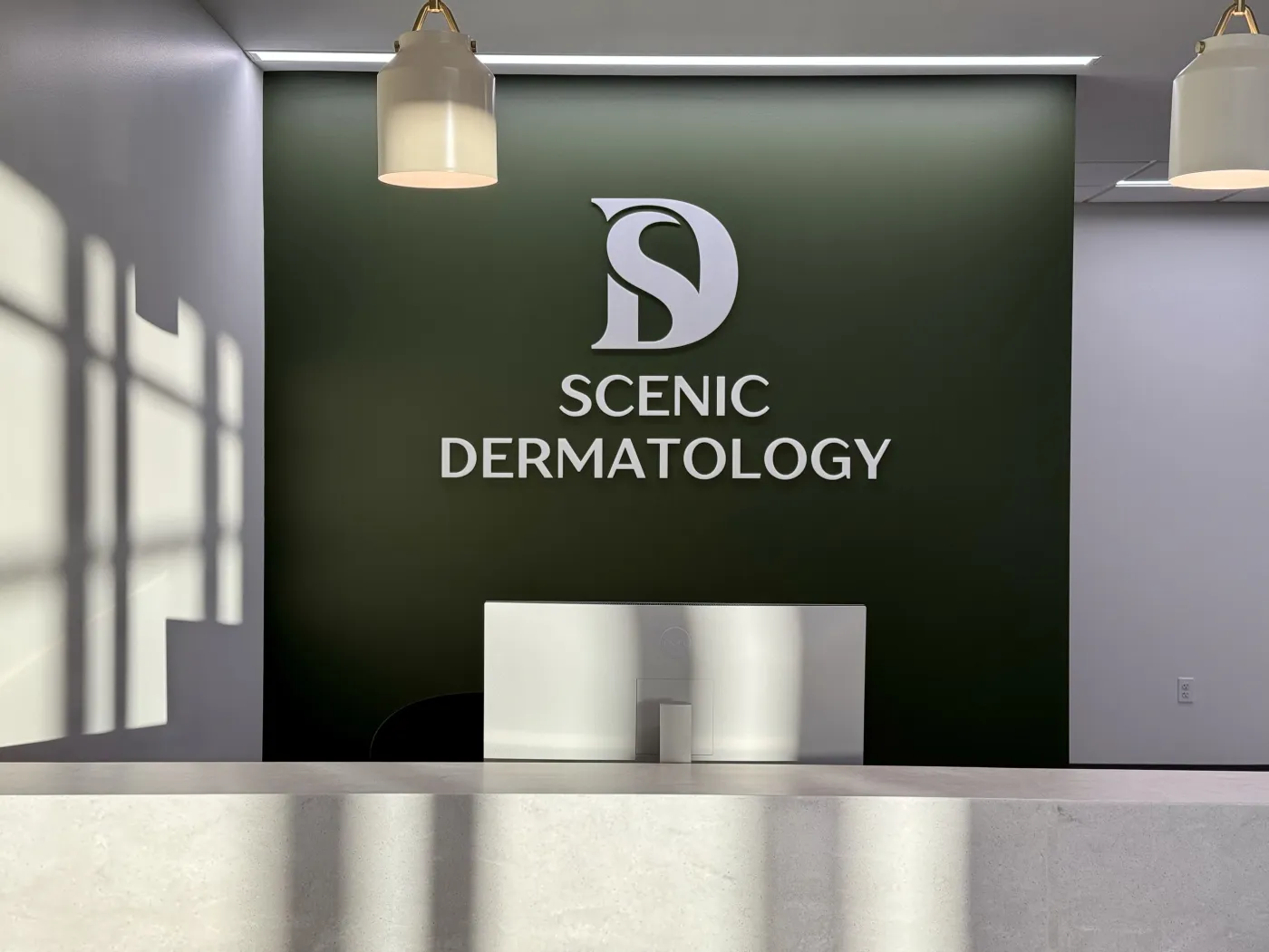 Scenic Dermatology reception desk and logo wall.